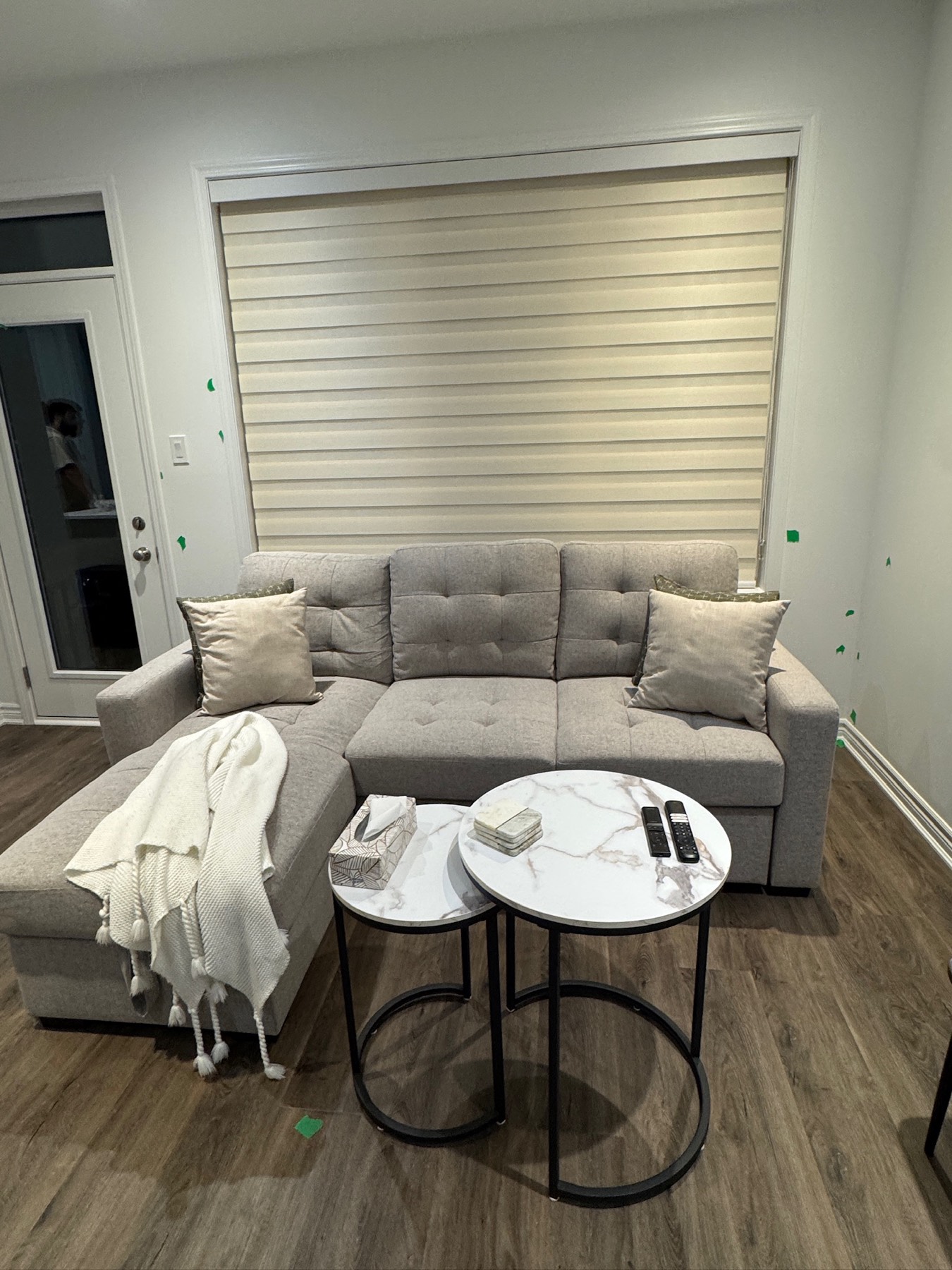Wide zebra shade covering a living room window above a sectional sofa